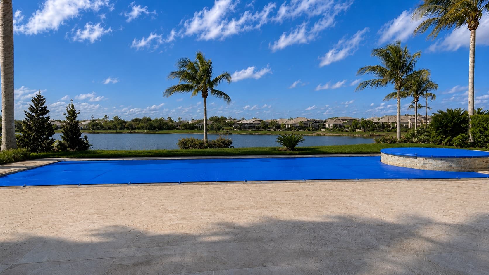 The same backyard pool by the lake covered edge-to-edge by an Pineapool walk-on safety cover, with no fence in sight