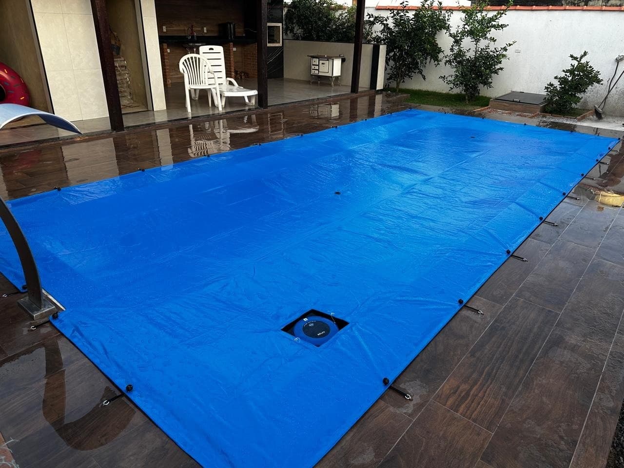 Pineapool pool safety cover in Robust Blue on a sunset rooftop deck