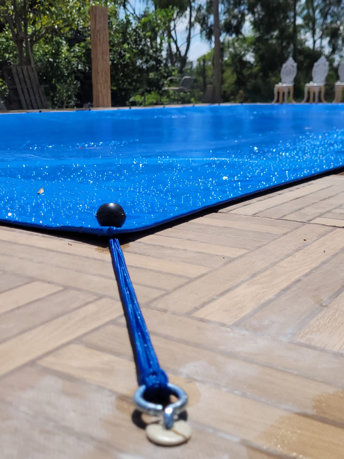 Close-up of the Pineapool cover's woven fabric, edge stitching, and stainless anchor fitting