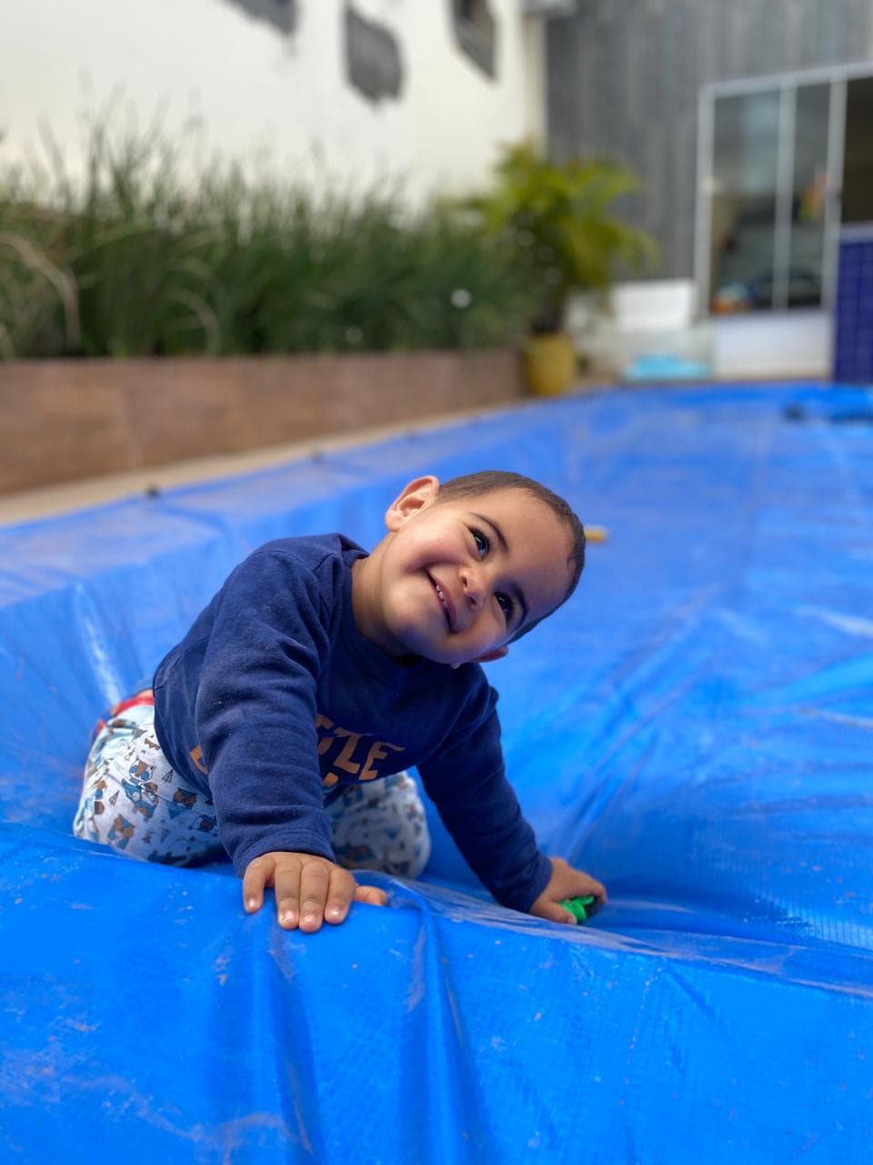 A toddler happily crawling on an Pineapool walk-on safety cover