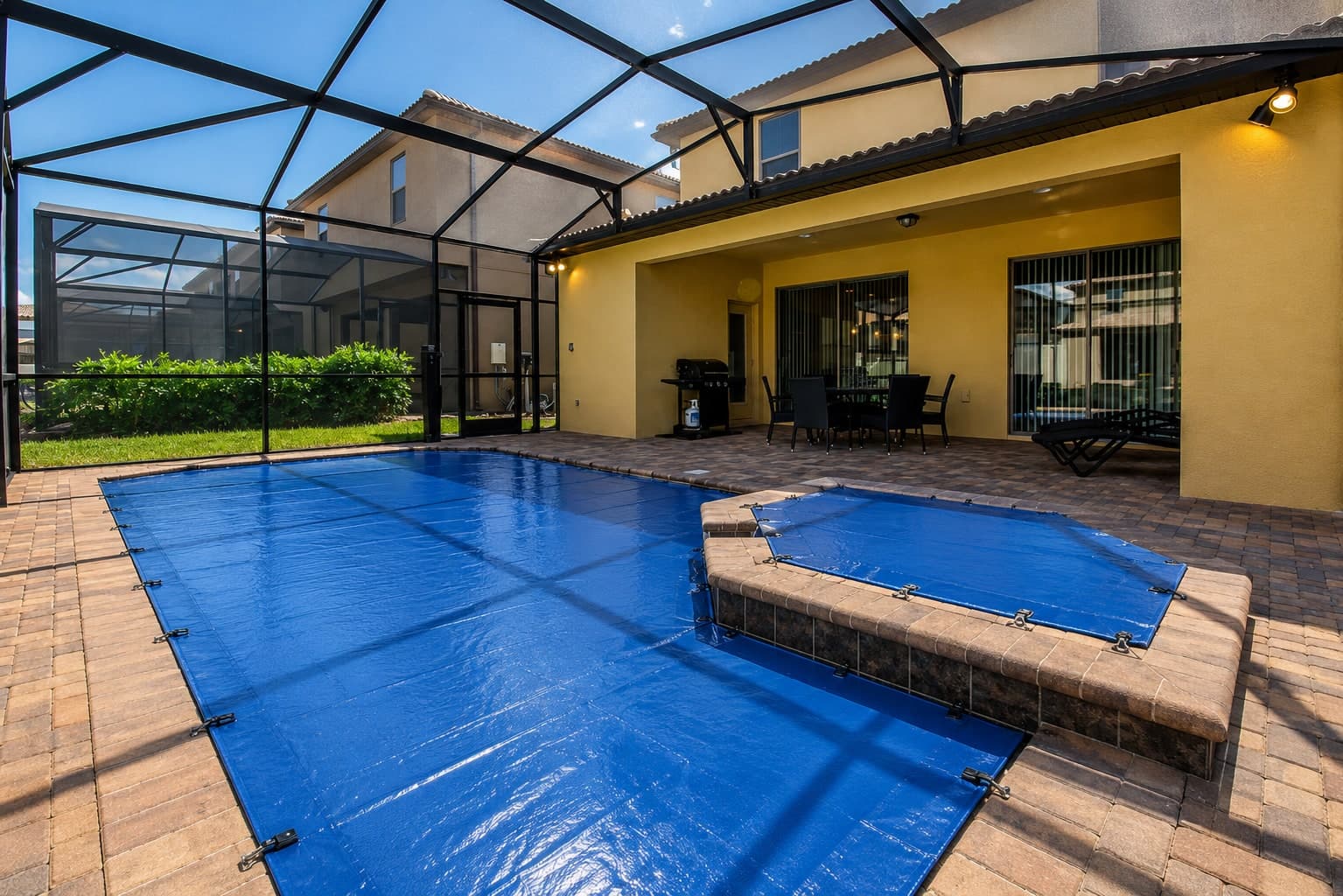 Pineapool cover anchored along a stone side deck, pulled flat and taut